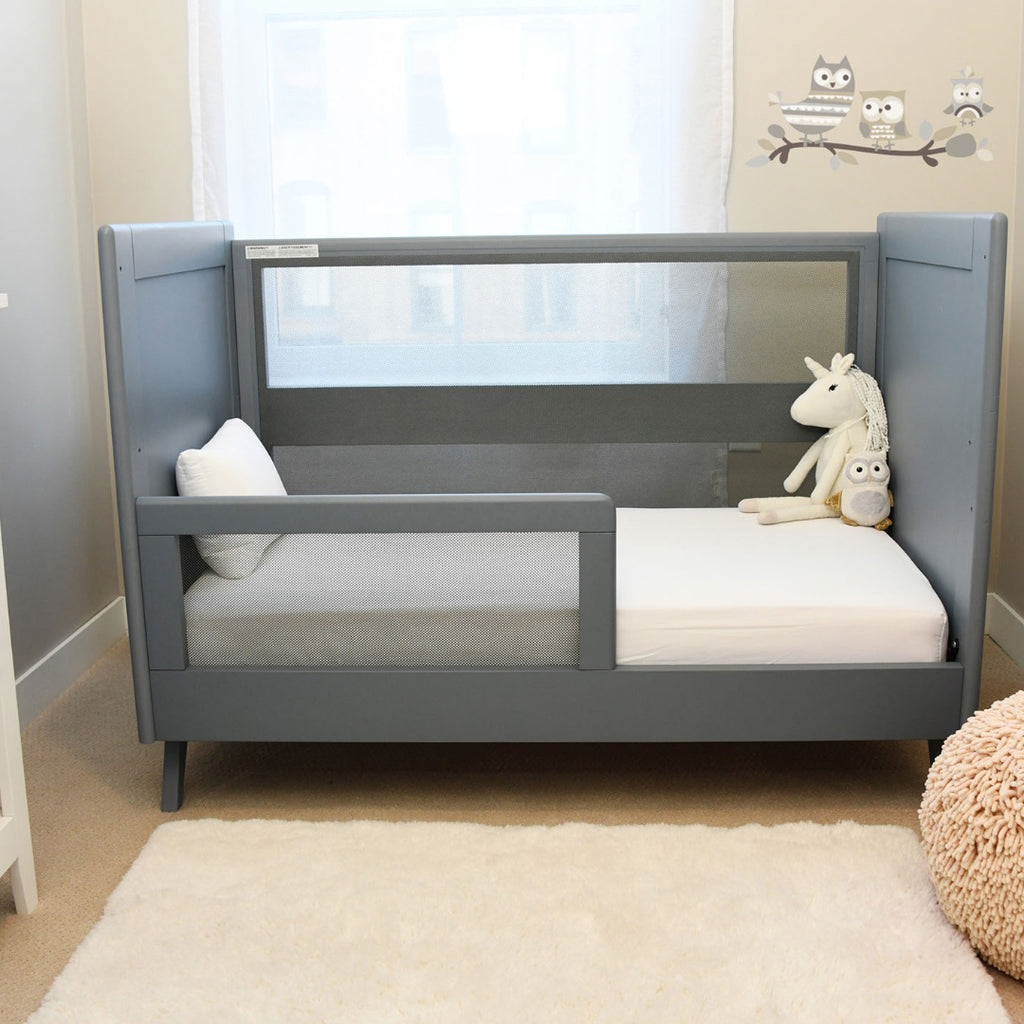 BreathableBaby Breathable Mesh Toddler Bed Conversion Kit in Steel Gray shown on converted toddler bed in nursery setting