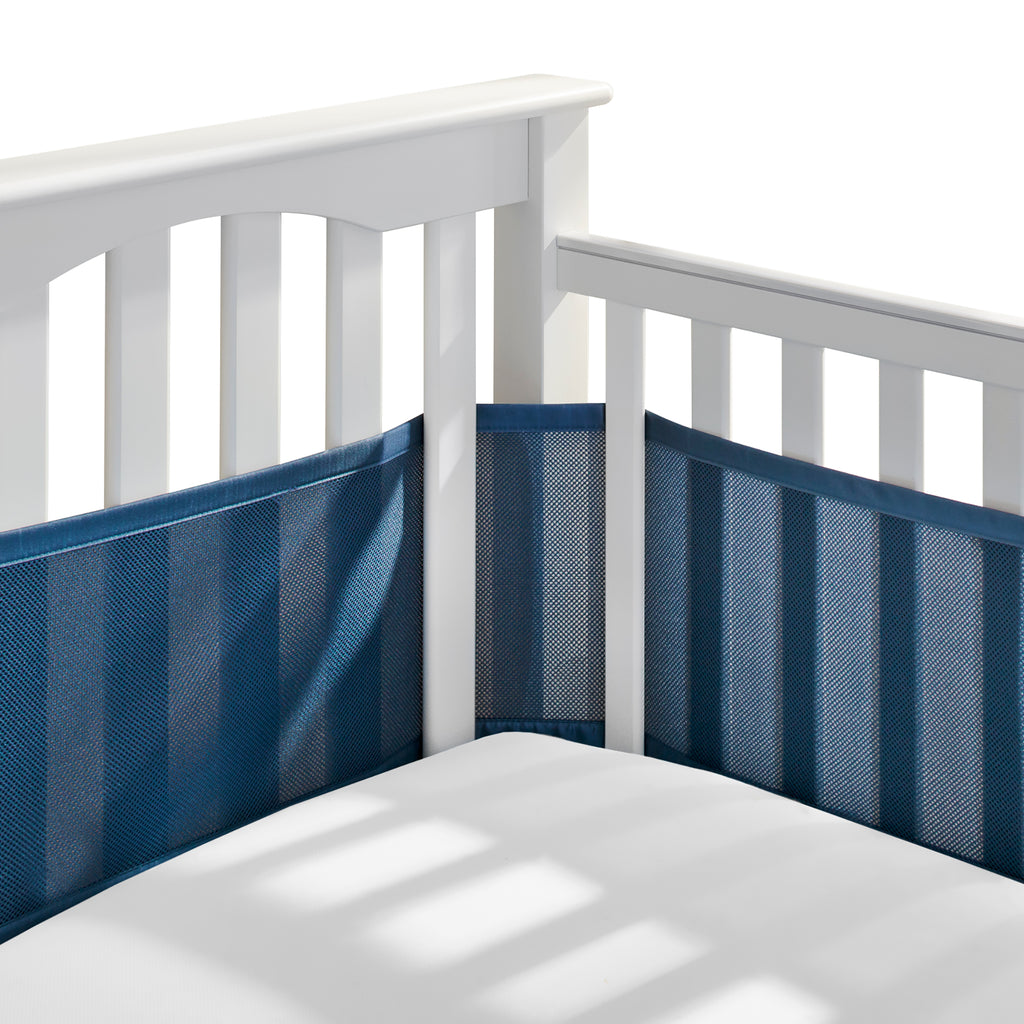 Corner view of BreathableBaby Breathable Mesh Crib Liner on a crib in Navy