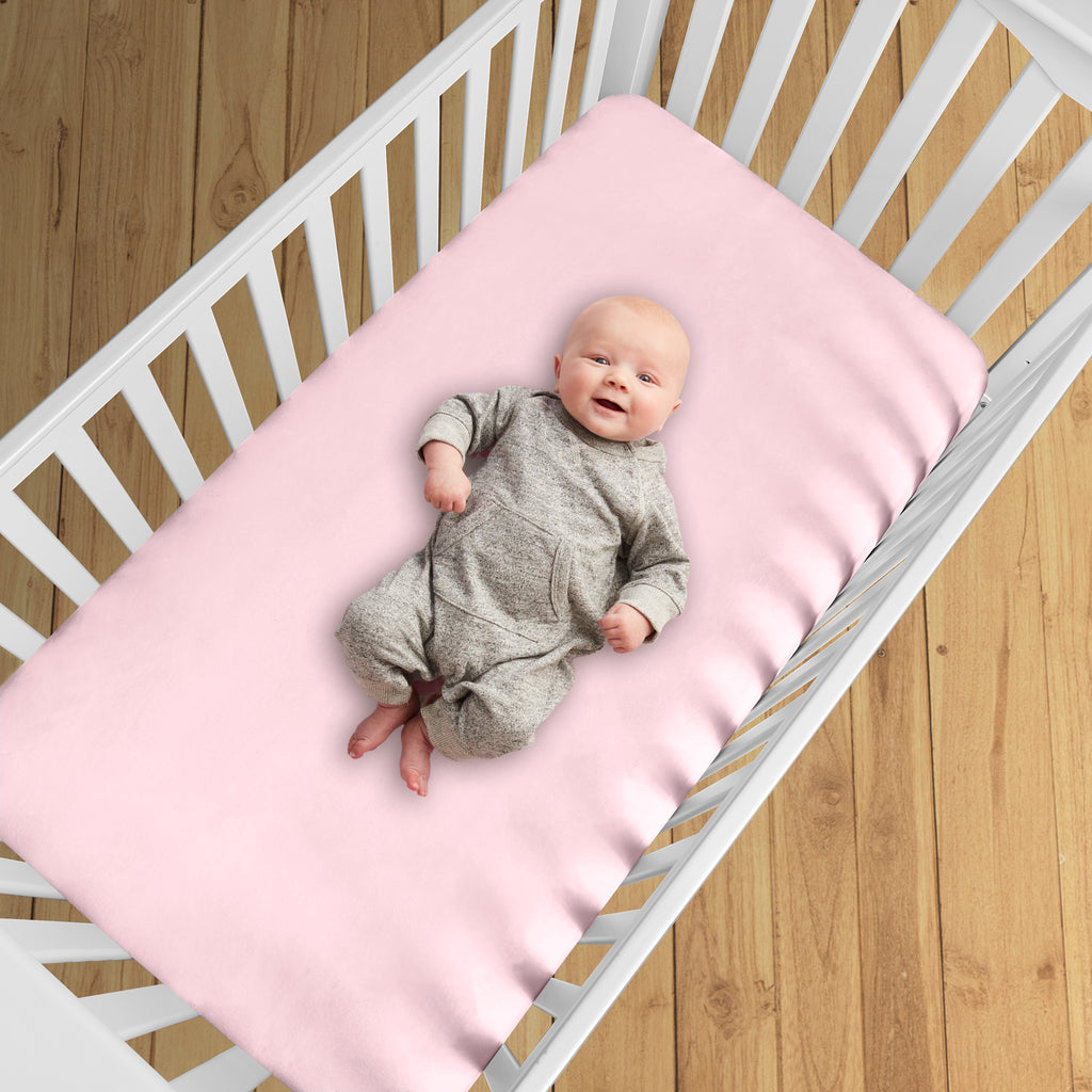BreathableBaby All-in-One Fitted Sheet & Waterproof Cover for Crib Mattresses in Pink Shown in Crib
