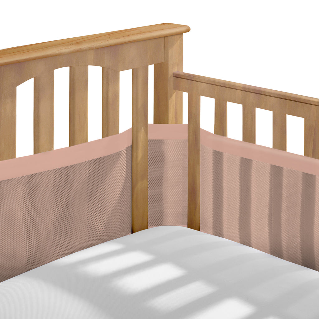 Corner view of BreathableBaby Breathable Mesh Crib Liner – Deluxe Muslin Collection on a crib in Shell Pink