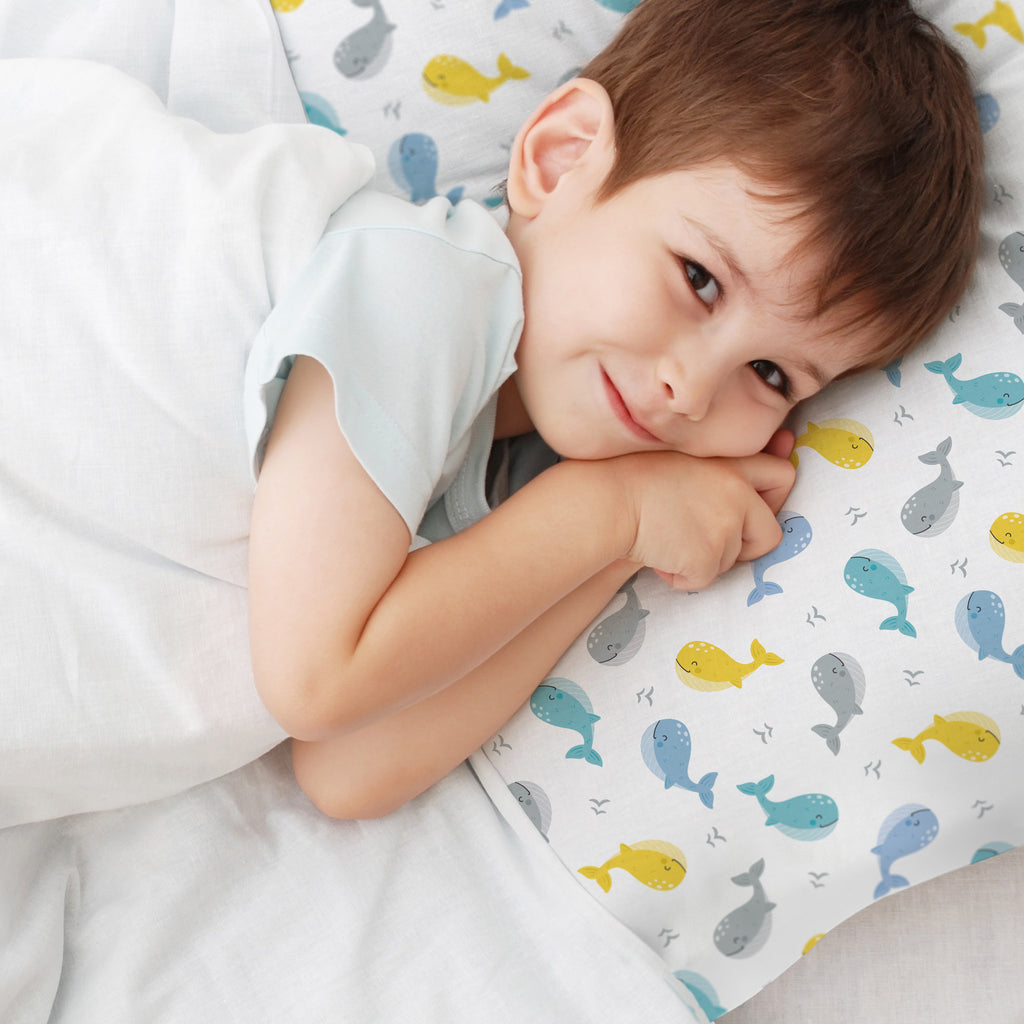 Child using BreathableBaby Cotton Percale Pillowcase for Toddler Pillow in Whales