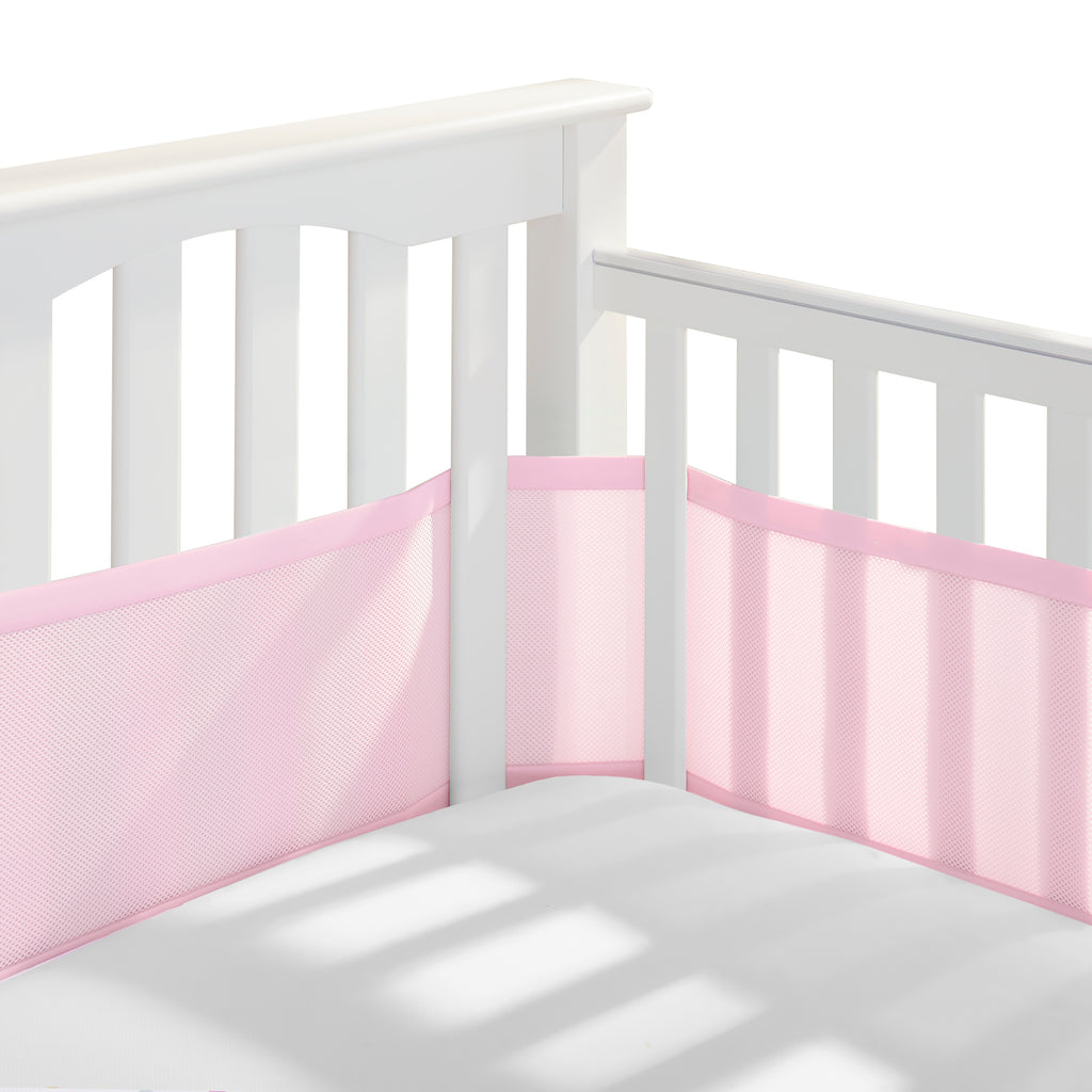 Corner view of BreathableBaby Breathable Mesh Crib Liner on a crib in Light Pink