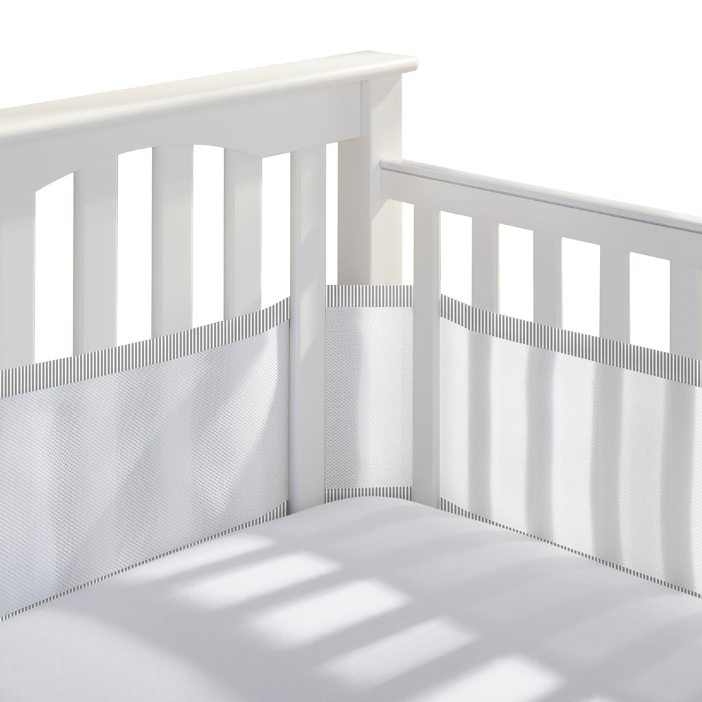 Corner view of BreathableBaby Breathable Mesh Crib Liner on a crib in White with Charcoal Seersucker Trim