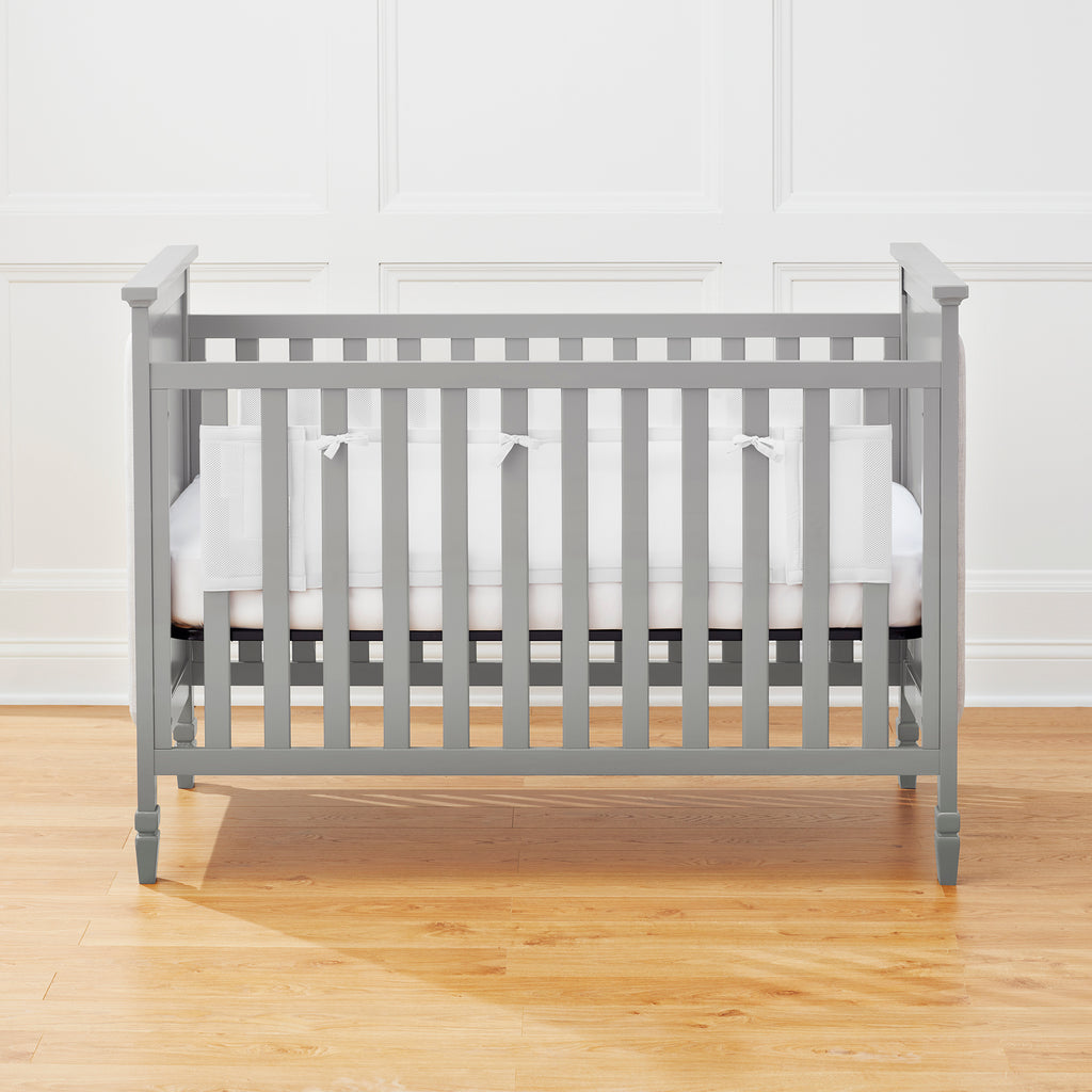 Full crib view of BreathableBaby Breathable Mesh Crib Liner on a solid end crib in White