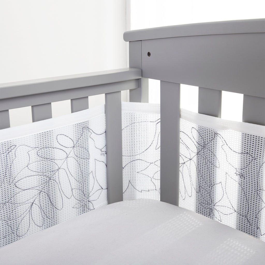 Corner view of BreathableBaby Breathable Mesh Crib Liner – Deluxe Embroidered Collection on a crib in Feathered Friends 