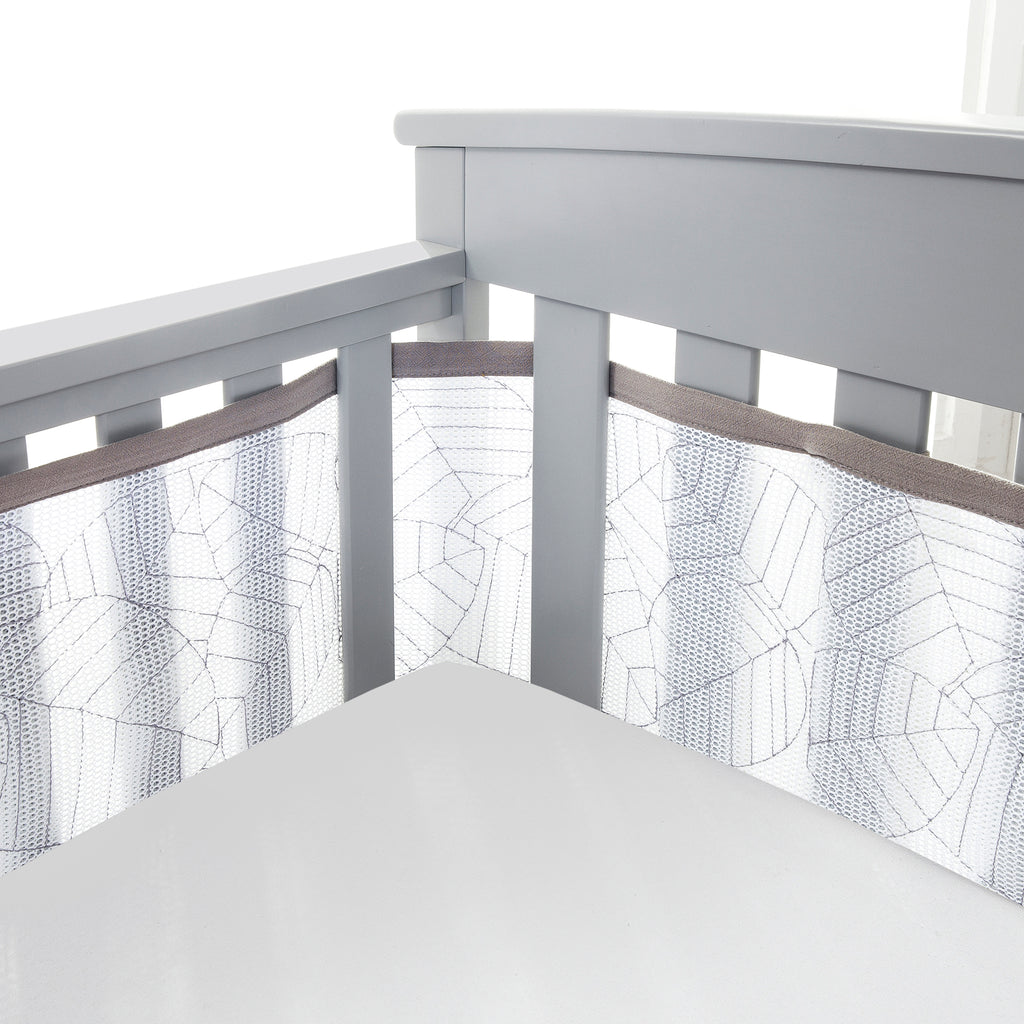 Corner view of BreathableBaby Breathable Mesh Crib Liner – Deluxe Embroidered Collection on a crib in Woodland Leaves 