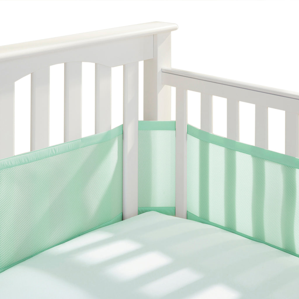 Corner view of BreathableBaby Breathable Mesh Crib Liner on a crib in Mint Green