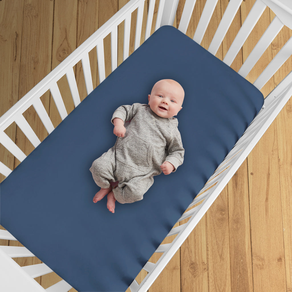 BreathableBaby All-in-One Fitted Sheet & Waterproof Cover for Crib Mattresses in Navy Shown in Crib